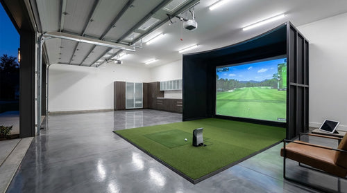 The Premium Garage Golf Simulator Package installed in a modern home garage, featuring a large impact screen and hitting mat.